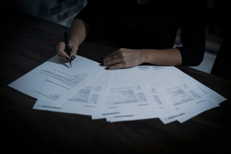 Property manager reviewing a rental application and verification documents at a desk