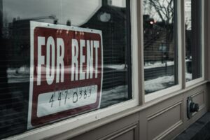 Tenant reviews a lease, calendar, and rent payment receipt at a kitchen table.