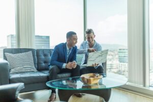 Property manager reviews a rental application and identification documents with a prospective tenant at a table.